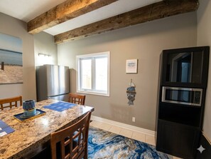 A kitchen with a granite countertop, wooden chairs, a refrigerator, and a microwave. - Waterfront Autumn getaway with private dome (Whitchurch-Stouffville)