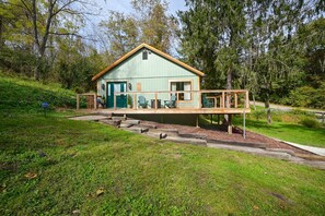 Een klein, gelijkvloers huisje met een veranda en een trap naar de ingang.