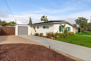 A single-story house with a garage, a paved driveway, and a well-maintained lawn. - Private Pool Oasis: Modern 3BR/2BA, Sleeps 8 (San Diego)