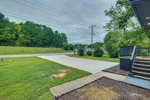 A paved driveway leading to a building with a covered entrance, surrounded by grass and trees. - Williamsburg Home for Colonial & Theme Park Trips (Williamsburg)