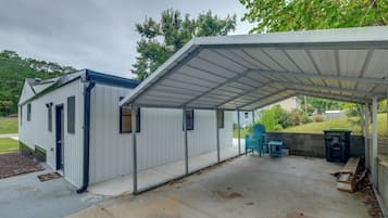 A covered outdoor area with a metal roof, a small shed, and a concrete patio.