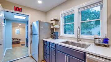 A modern kitchen with a built-in refrigerator, a sink, and a coffee maker.