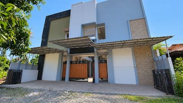A modern two-story building with a covered entrance and a brick section on the right.