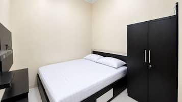 A bedroom with a bed, a wardrobe, and a desk.