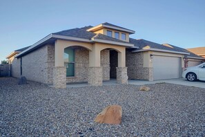A residential house with a stone facade, a garage, and a gravel driveway. - 9 Mi to Dtwn! Odessa Home w/ Private Yard (Odessa)