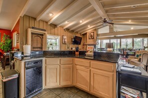 A kitchen with wooden cabinets, a black countertop, and a built-in oven. - Walk to Midtown! Mountain-View Ruidoso Retreat (Ruidoso)