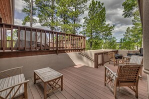 A wooden deck with outdoor furniture, including chairs and a table, surrounded by trees. - Walk to Midtown! Mountain-View Ruidoso Retreat (Ruidoso)