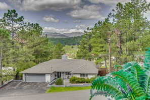 A residential house with a garage, surrounded by trees and a mountainous landscape in the background. - Walk to Midtown! Mountain-View Ruidoso Retreat (Ruidoso)