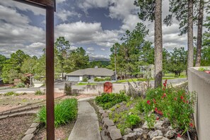 A residential area with a house, a paved driveway, and a stone pathway leading to the entrance. - Walk to Midtown! Mountain-View Ruidoso Retreat (Ruidoso)