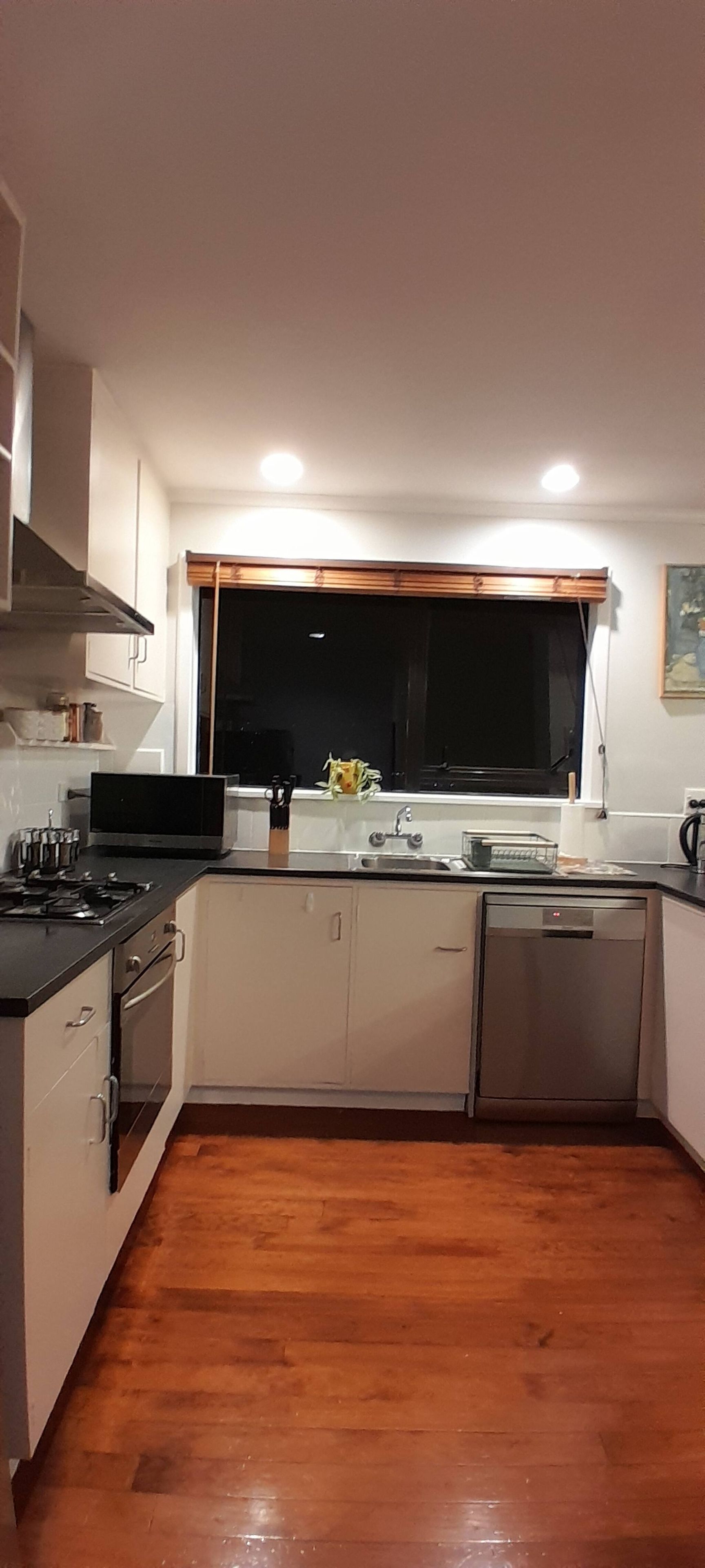A compact kitchen with a stove, sink, and cabinets.