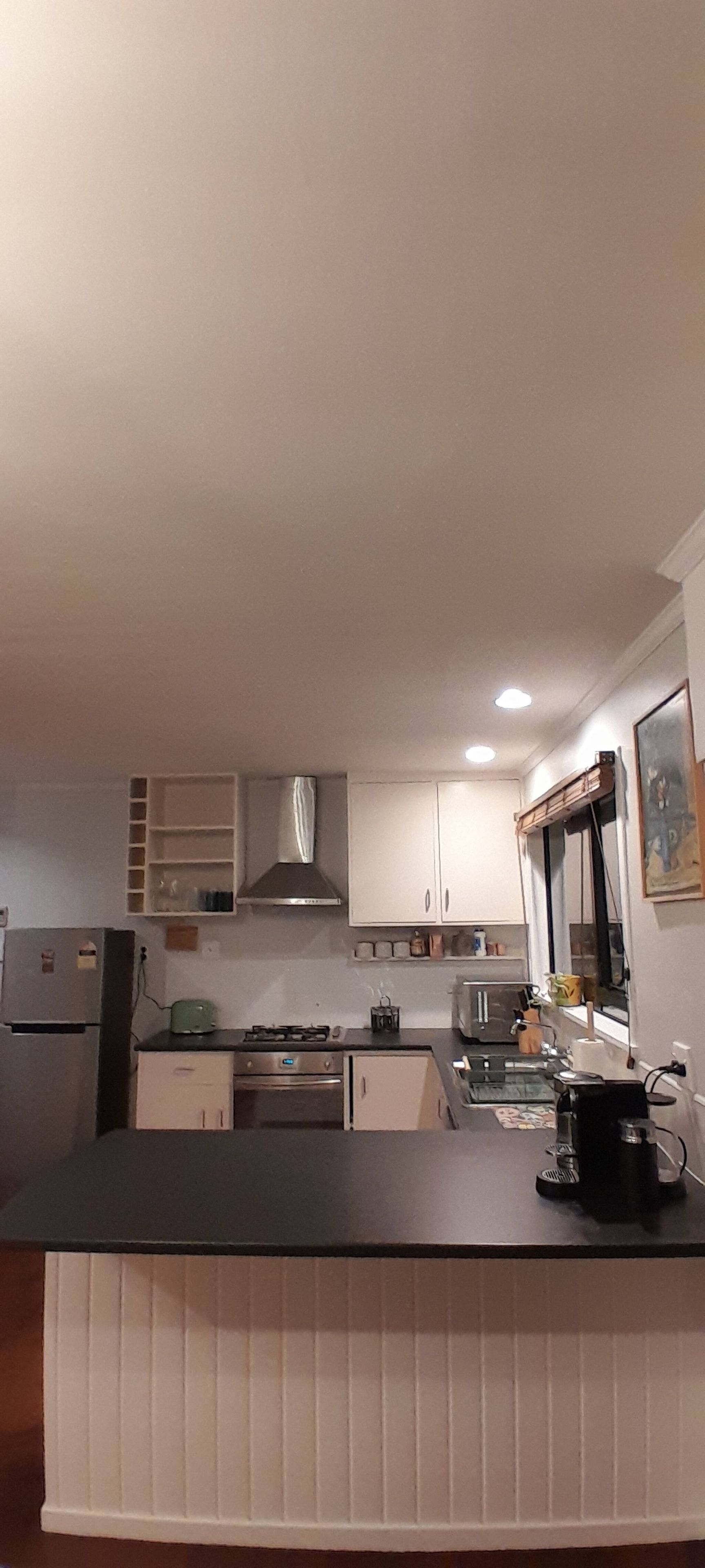 A compact kitchen with a central island, a built-in oven, and a microwave.