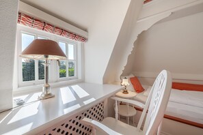 A small, white room with a window, a desk, a chair, and a bed. - Loddis Leev, Germany (Kampen (Sylt))
