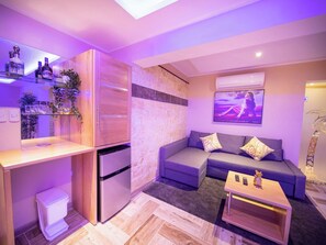 A compact living space with a kitchenette, a sofa set, and a flat-screen TV mounted on the wall. - Luxury Villa with Pool, Jacuzzi & Beach Access (Sosúa)