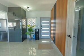 A modern kitchen with stainless steel appliances, a potted plant, and a water dispenser.