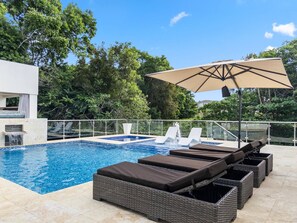 A pool area with lounge chairs, a hot tub, and a large umbrella. - Luxury BOSS Villa in Sosua Hispaniola (Sosúa)