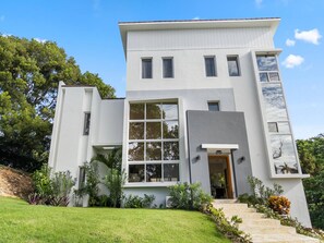 A modern two-story house with a flat roof, large windows, and a front entrance. - Luxury BOSS Villa in Sosua Hispaniola (Sosúa)