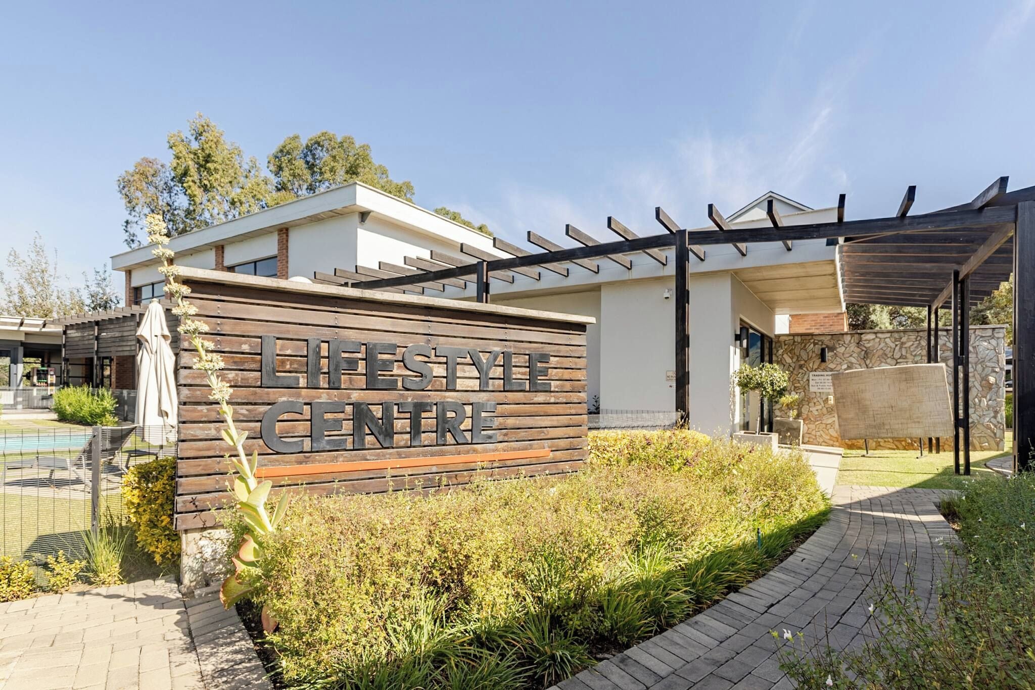 A modern building with a sign reading 'LIFESTYLE CENTRE' and a covered outdoor area.