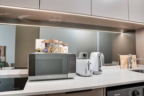 A modern kitchen with a built-in microwave, toaster, and coffee maker. - Rosebank Retreat, business or leisure (Johannesburg)