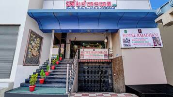 A hotel entrance with a staircase, a signboard, and a decorative mural.
