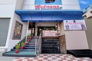 A hotel entrance with a staircase, a signboard, and a decorative mural.