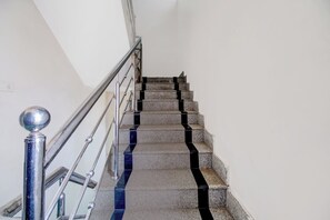A staircase with a metal handrail and a glass balustrade.