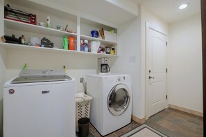 A laundry room with a Maytag dryer, a washing machine, and shelves above containing cleaning supplies. - 2 Boat Docks! Marble Falls Lake Retreat (Marble Falls)