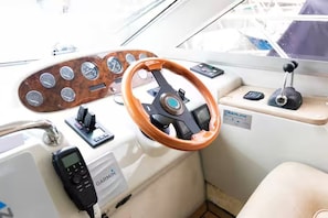 A boat's control panel with a wooden steering wheel, a Garmin device, and a manual gear shift. - Karvatoftir, Fuglafjørður 530 (Fuglafjørður)