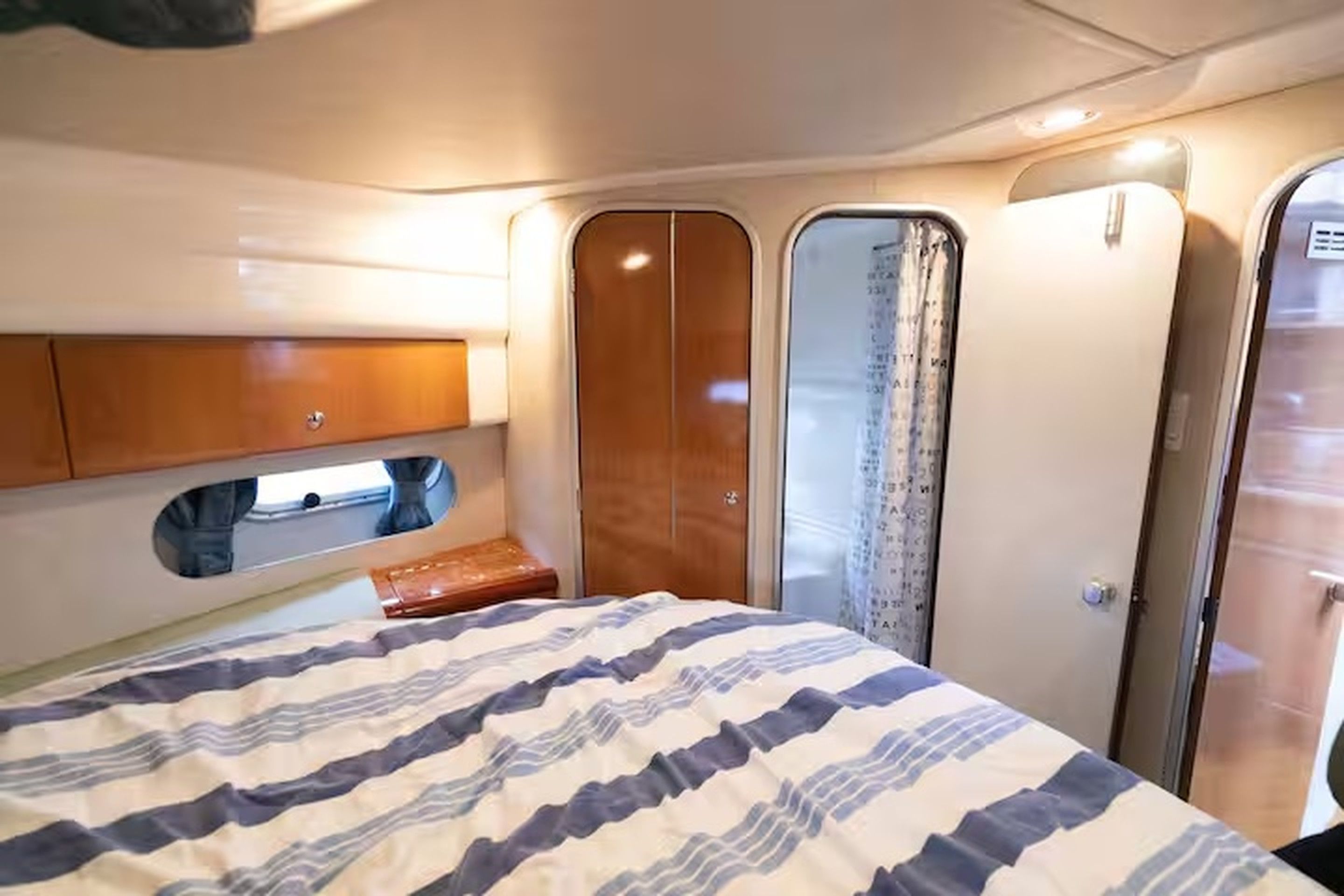 Habitació petita i funcional amb llit, armari i una zona de seients.