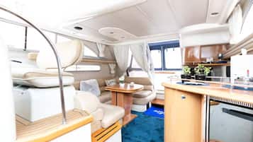 Un espacio interior compacto con comedor, kitchenette y zona de estar.