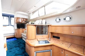 A compact kitchen with a sink, stove, and cabinets.