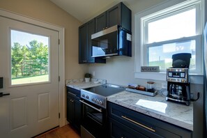 A modern kitchen with a built-in stove, oven, and coffee maker. - 1 Mi to Floyd Country Store: Cozy Mtn Cottage (Floyd)