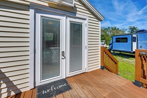 A house with a double door, a welcome mat, and a deck. - Castaway Creek Cabin - Horse Creek Retreat Arcadia (Arcadia)