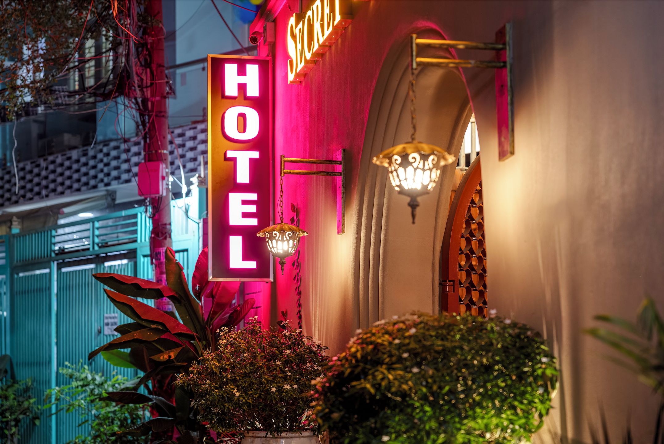 A hotel sign with a neon 'HOTEL' sign and a traditional lantern.