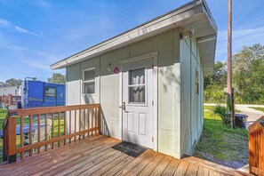 A small, single-story building with a wooden deck and a door.