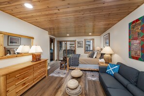 A cozy room with wooden furniture, a large mirror, and a colorful poster on the wall. - New Listing! Ski-In/Ski-Out with Indoor Hot Tub in Big Sky (Big Sky)