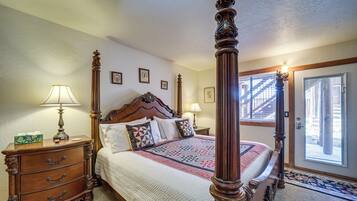 Un lit à baldaquin avec une tête de lit en bois, une table de chevet avec une lampe et une commode avec des tiroirs.