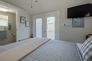 A bedroom with a bed, a mounted television, a window with blinds, and a wall-mounted thermostat. - Otter Creek Cabin - Horse Creek Retreat Arcadia (Arcadia)