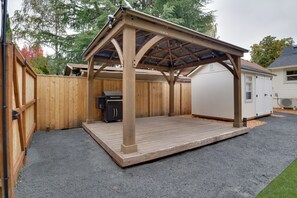 A covered patio area with a grill and a wooden deck. - Walk to Old Town Eats, Shops! Modern Home w/ Yard (Sherwood)