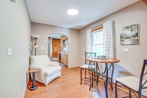 A modern living room with a sofa, a small round table, and a dining area with a chair. - Cozy Vintage Charm Located Between US 60 & I-64 (Ashland)