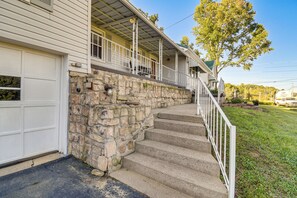 A two-story house with a stone foundation, a covered porch, and a garage. - Cozy Vintage Charm Located Between US 60 & I-64 (Ashland)