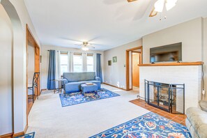 A living room with a sofa, a fireplace, and a ceiling fan. - Cozy Vintage Charm Located Between US 60 & I-64 (Ashland)