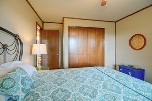 A bedroom with a bed, a nightstand, a lamp, a dresser, and a round mirror on the wall. - 3 Mi to Norfork Lake! Multi-Level Haven for Groups (Mountain Home)