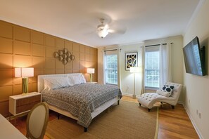 A bedroom with a bed, bedside lamps, a chair, a floor lamp, and a TV on the wall. - Rehoboth Beach Group Getaway! 5 Mi to Boardwalk (Rehoboth Beach)