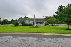 Une maison à deux étages avec une pelouse devant et un drapeau américain.
