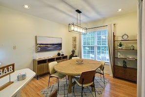 A dining area with a round table, chairs, a hanging light fixture, and a window with blinds. - Rehoboth Beach Group Getaway! 5 Mi to Boardwalk (Rehoboth Beach)