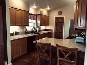 Una cocina con armarios de madera, encimera de granito y estufa integrada.