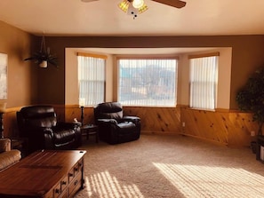 A living room with two leather chairs, a wooden coffee table, and a ceiling fan. - Poncha Springs Home Near Salida & Buena Vista (Poncha Springs)