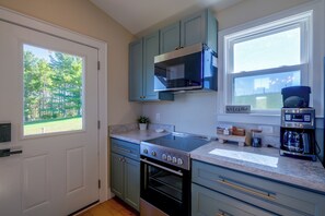 A kitchen with a built-in oven, a coffee maker, and a view of the outdoors. - Hike, Explore & Unwind: Scenic Blue Ridge Escape (Floyd)