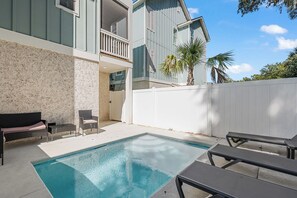 A residential pool area with a clear blue pool, a white fence, and a balcony. - Brand New Retreat Private Pool & Golf Simulator (Hilton Head)