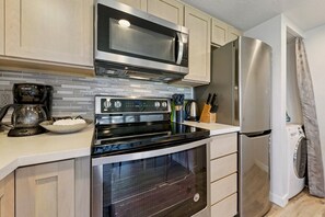 A modern kitchen with a stainless steel refrigerator, a microwave, an oven, and a coffee maker. - 489 Tahoe Keys Blvd, Unit 69 1 Bedroom Condo (South Lake Tahoe)